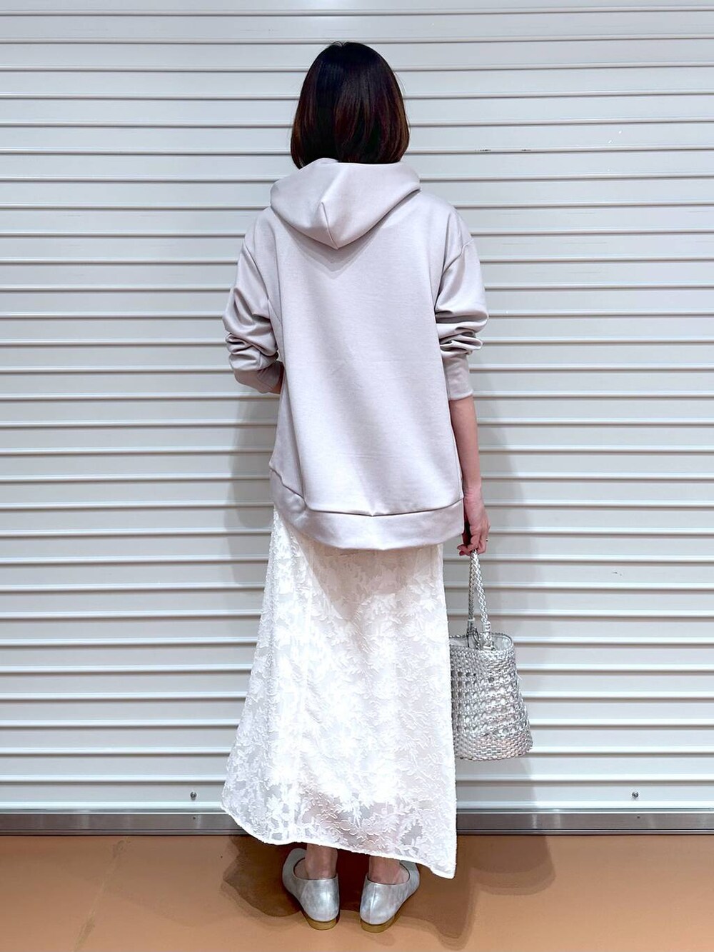 ベージュ系のパーカー、シルバー系のパンプス、ホワイト系のスカートを着用したレディースの春コーディネートの4枚目の写真