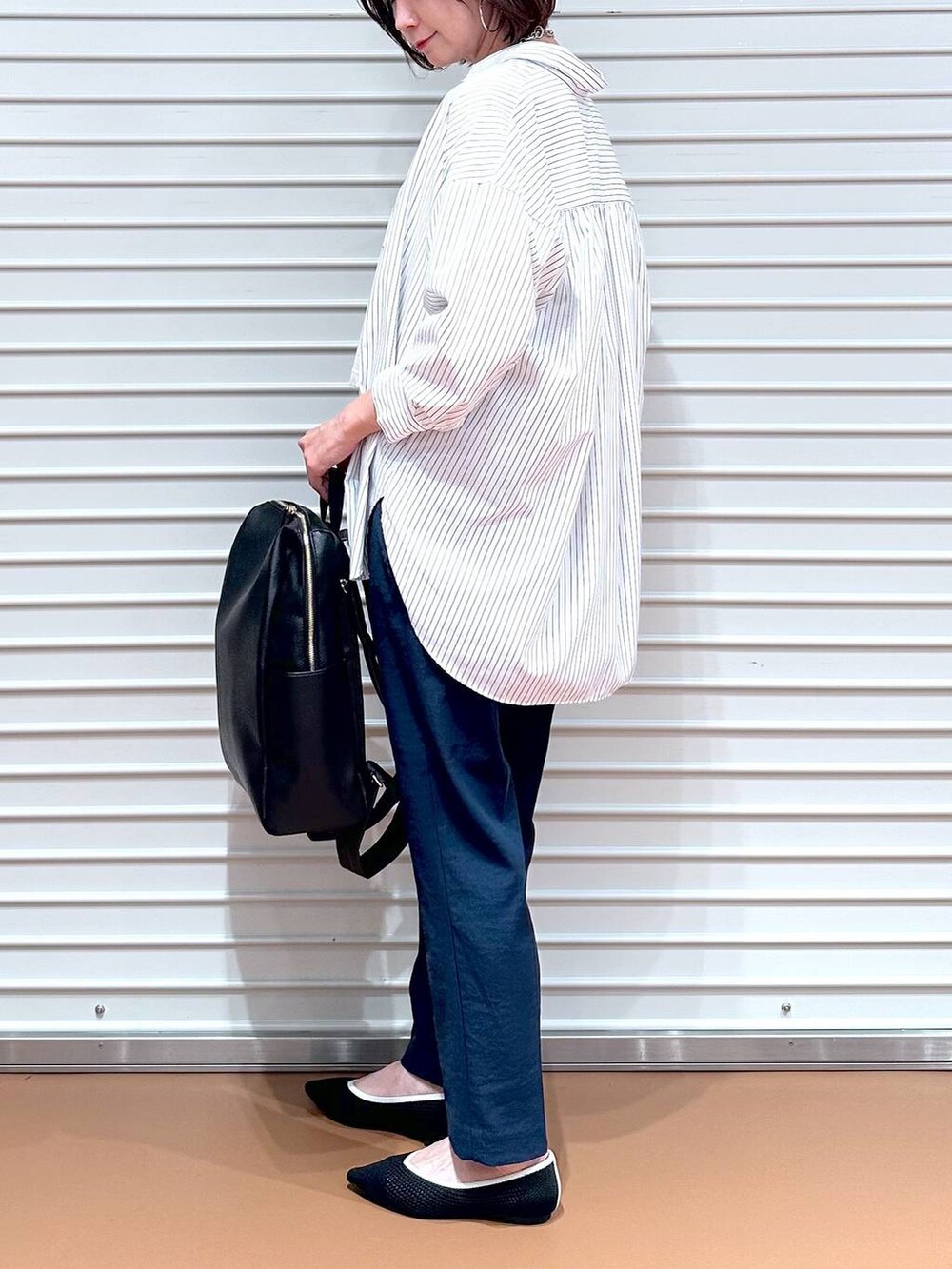 ブラック系のパンプス、ホワイト系のシャツ/ブラウス、ブラック系のバックパック/リュックを着用したレディースの春コーディネートの7枚目の写真