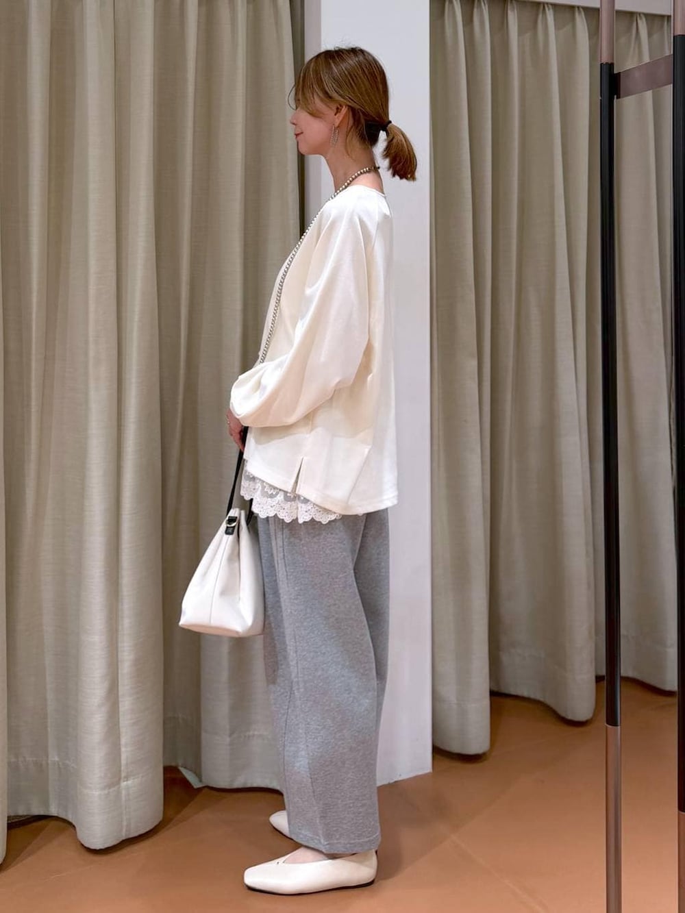 ホワイト系のパンプス、ホワイト系のタンクトップ、グレー系のスウェットパンツを着用したレディースの春コーディネートの3枚目の写真