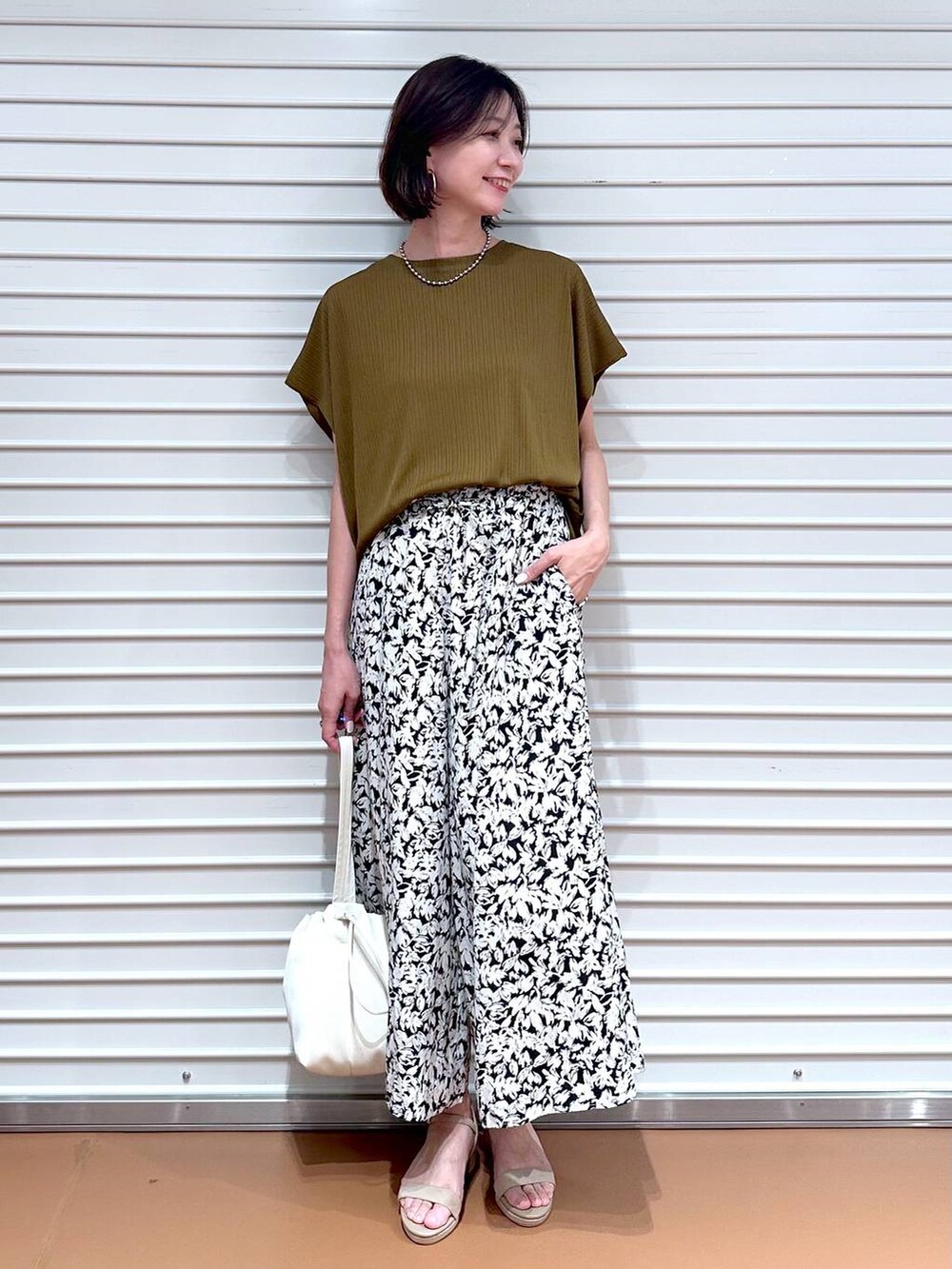 グリーン系のTシャツ/カットソー、ベージュ系のサンダル、ブラック系のその他パンツを着用したレディースの夏コーディネートの2枚目の写真