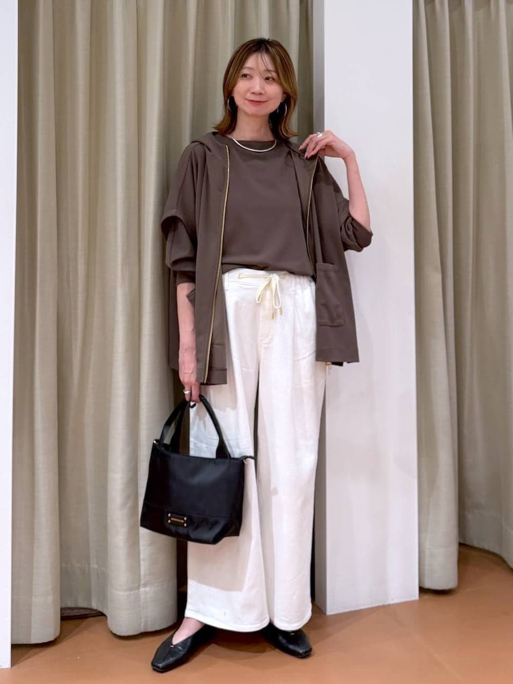 ブラック系のパンプス、ホワイト系のデニムパンツ、ブラウン系のTシャツ/カットソーを着用したレディースの春コーディネートの2枚目の写真