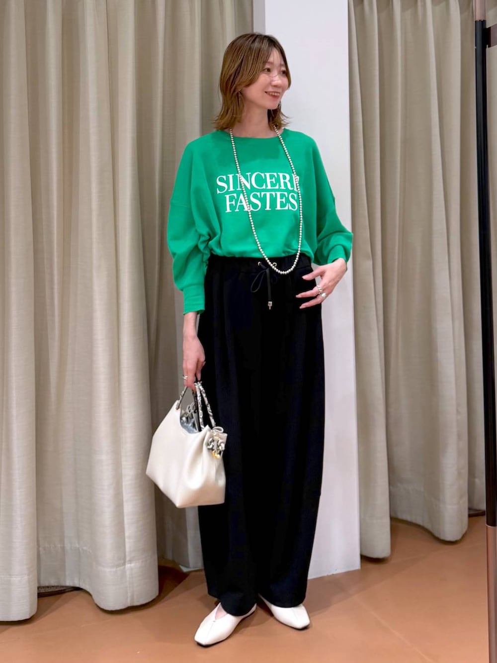 ホワイト系のパンプス、ブラック系のその他パンツ、ホワイト系のハンドバッグを着用したレディースの春コーディネートの6枚目の写真