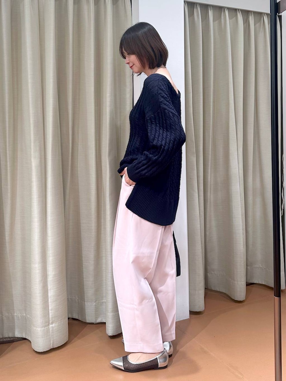 ブルー系のニット/セーター、ブラック系のハンドバッグ、シルバー系のパンプスを着用したレディースの冬コーディネートの5枚目の写真