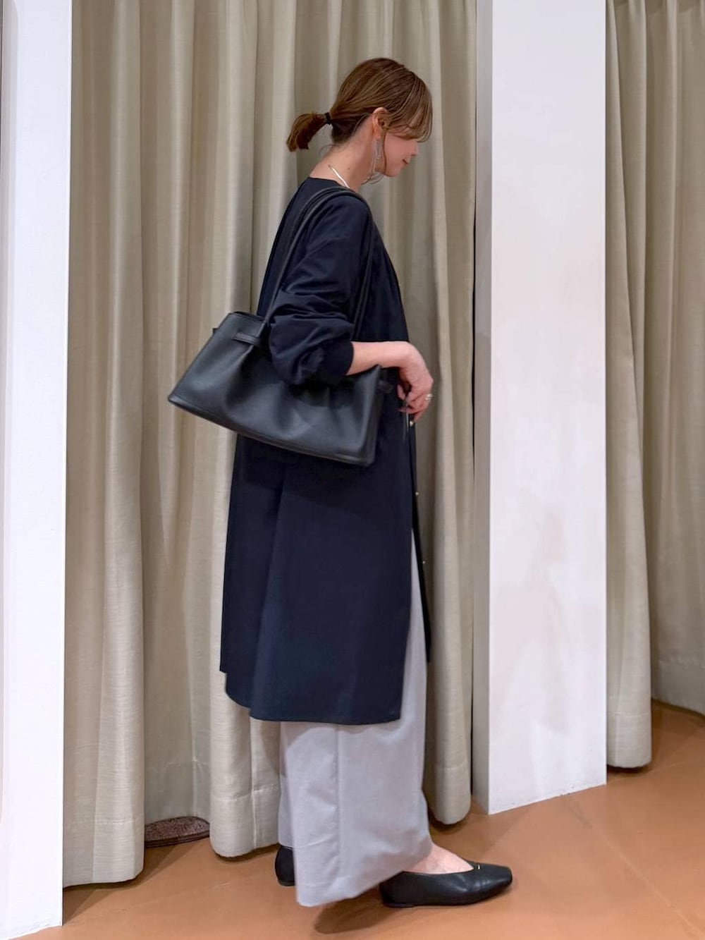 ホワイト系のニット/セーター、ブラック系のパンプス、ブルー系のノーカラーコートを着用したレディースの春コーディネートの5枚目の写真