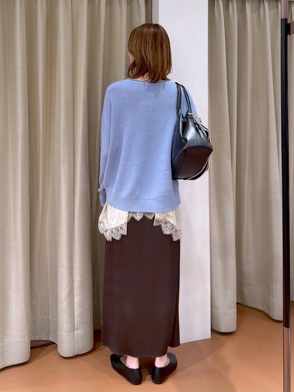 ブルー系のニット/セーター、ブラック系のパンプス、ブラウン系のスカートを着用したレディースの春コーディネートの4枚目の写真