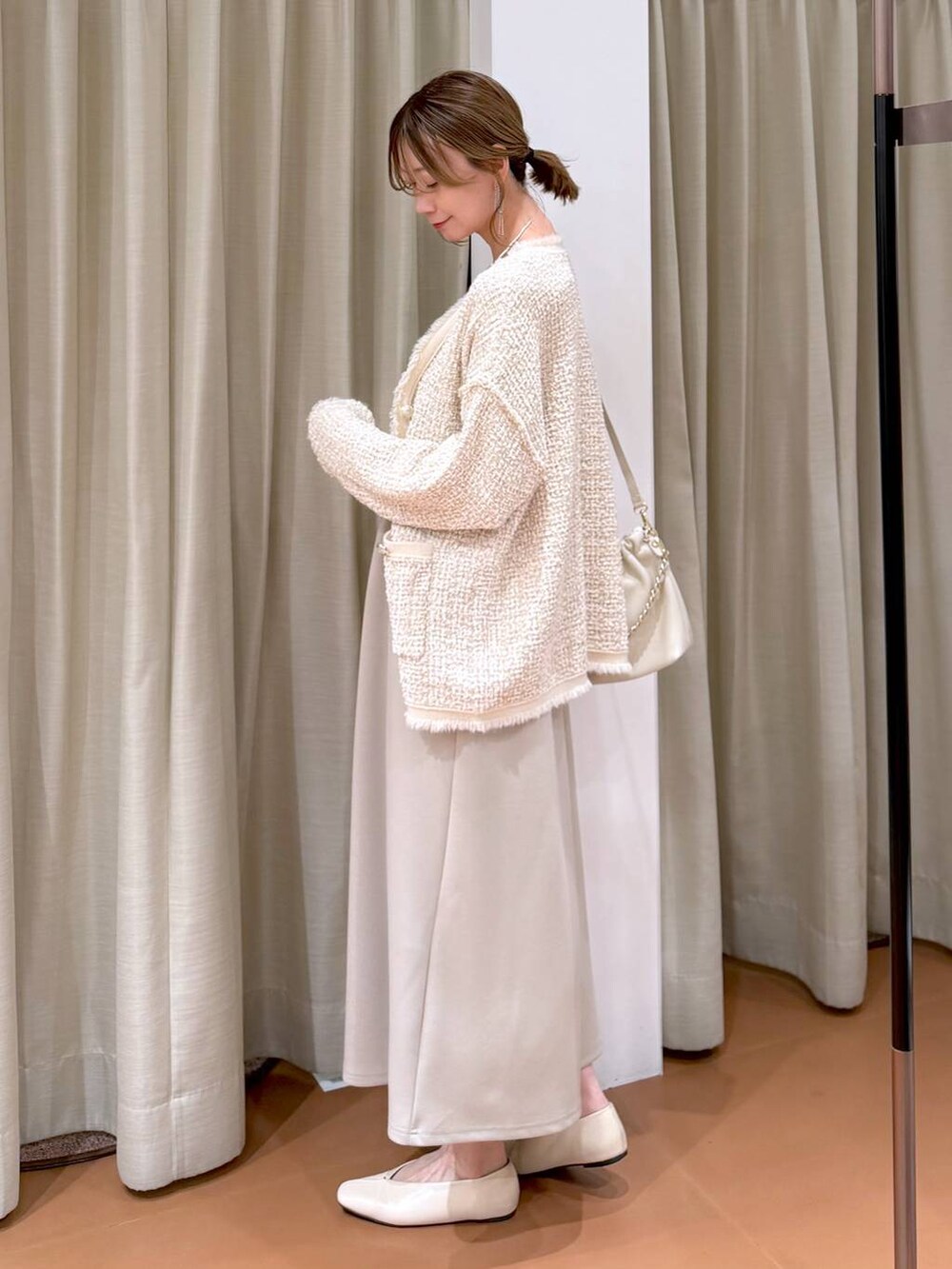 グレー系のTシャツ/カットソー、ホワイト系のハンドバッグ、ホワイト系のパンプスを着用したレディースの春コーディネートの3枚目の写真