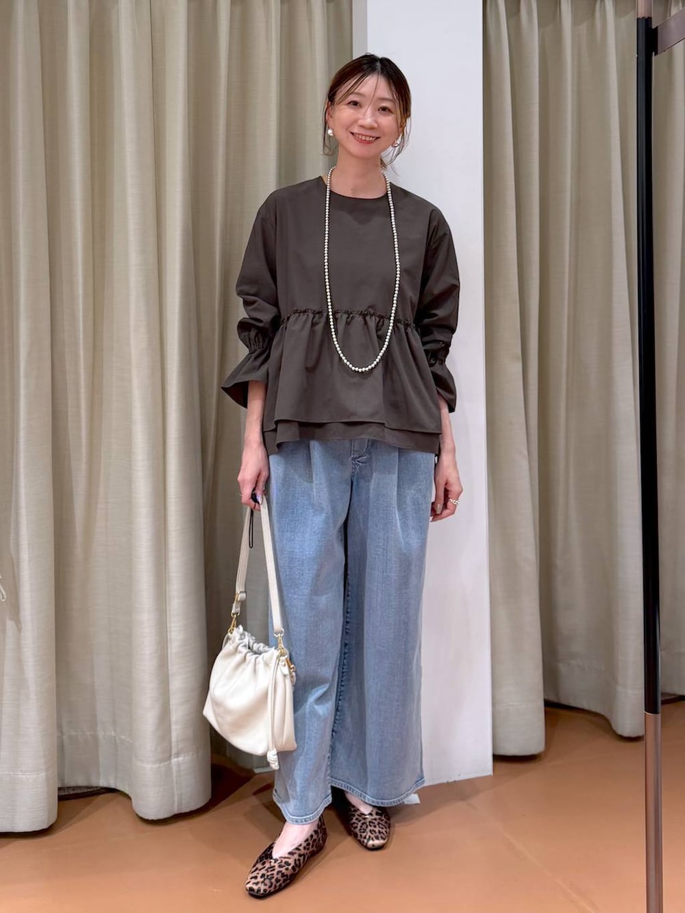 ホワイト系のハンドバッグ、ブルー系のデニムパンツ、ブラウン系のシャツ/ブラウスを着用したレディースの冬コーディネートの2枚目の写真