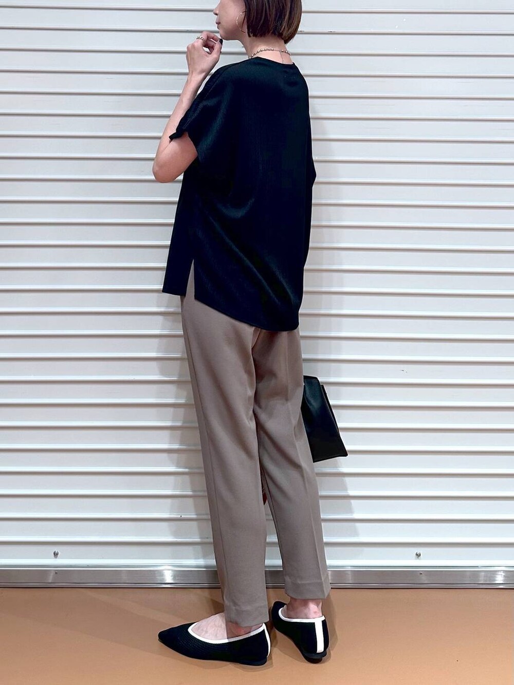 ブラック系のパンプス、ブラック系のショルダーバッグ、シルバー系のネックレスを着用したレディースの夏コーディネートの6枚目の写真