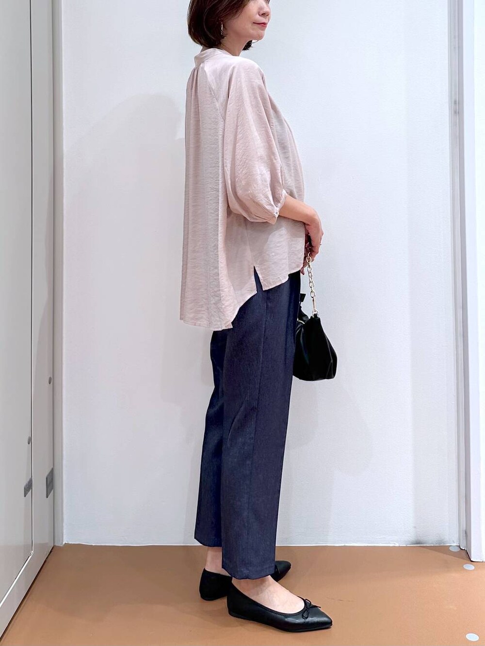 ベージュ系のシャツ/ブラウス、ブラック系のパンプス、ブルー系のデニムパンツを着用したレディースの秋コーディネートの6枚目の写真