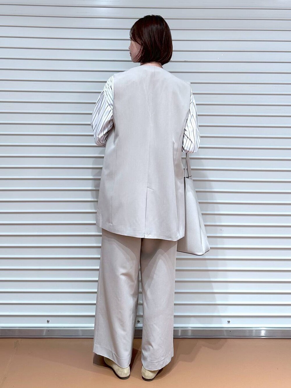 ブラック系のシャツ/ブラウス、ベージュ系のその他パンツ、ベージュ系のベストを着用したレディースの秋コーディネートの4枚目の写真