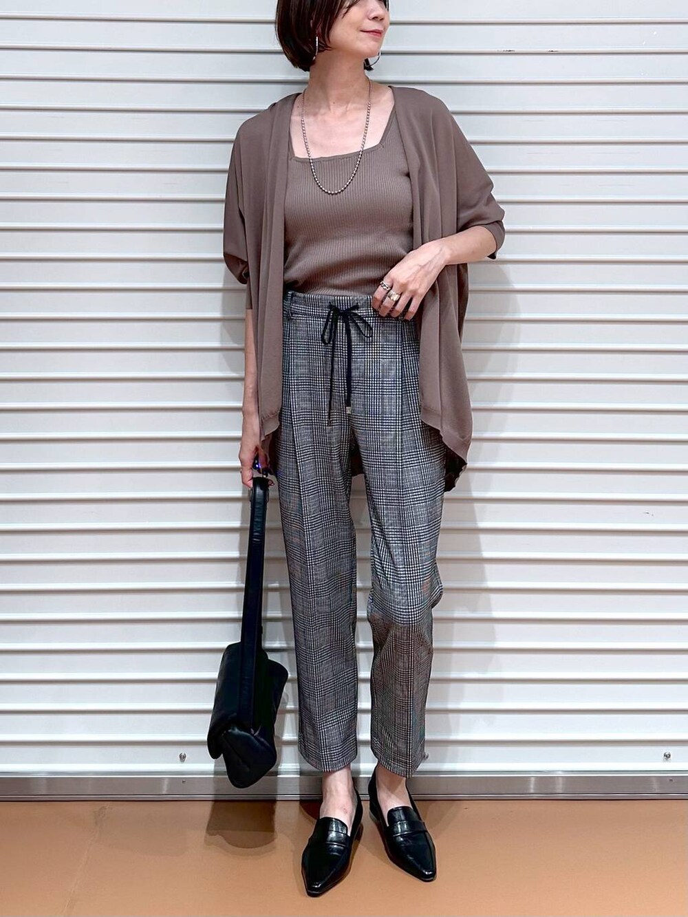 ブラウン系のカーディガン/ボレロ、ブラック系のその他パンツ、ブラウン系のタンクトップを着用したレディースの秋コーディネートの5枚目の写真