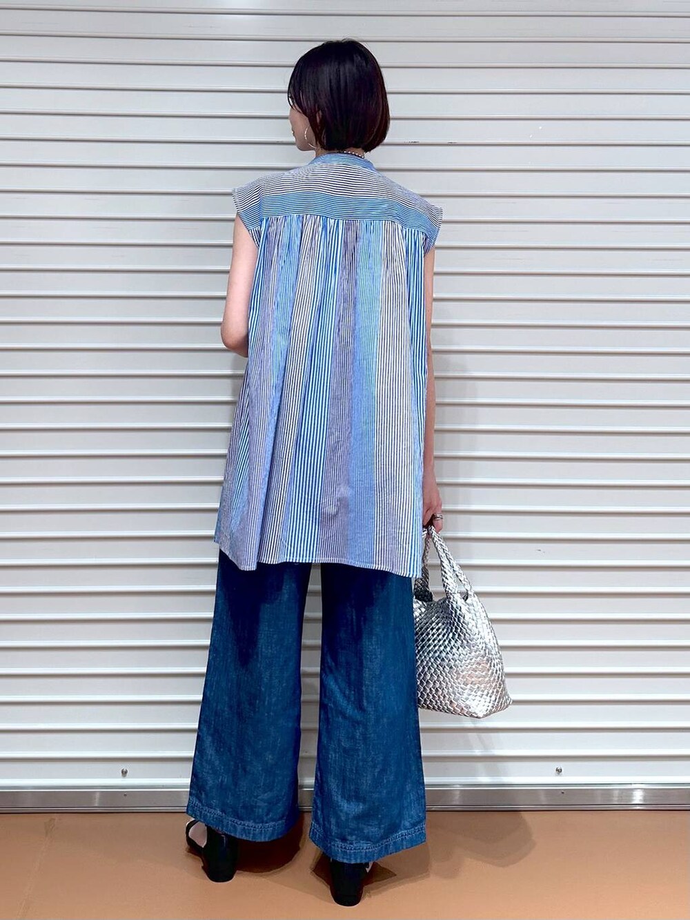 ブルー系のデニムパンツ、ブルー系のデニムパンツ、シルバー系のトートバッグを着用したレディースの夏コーディネートの4枚目の写真