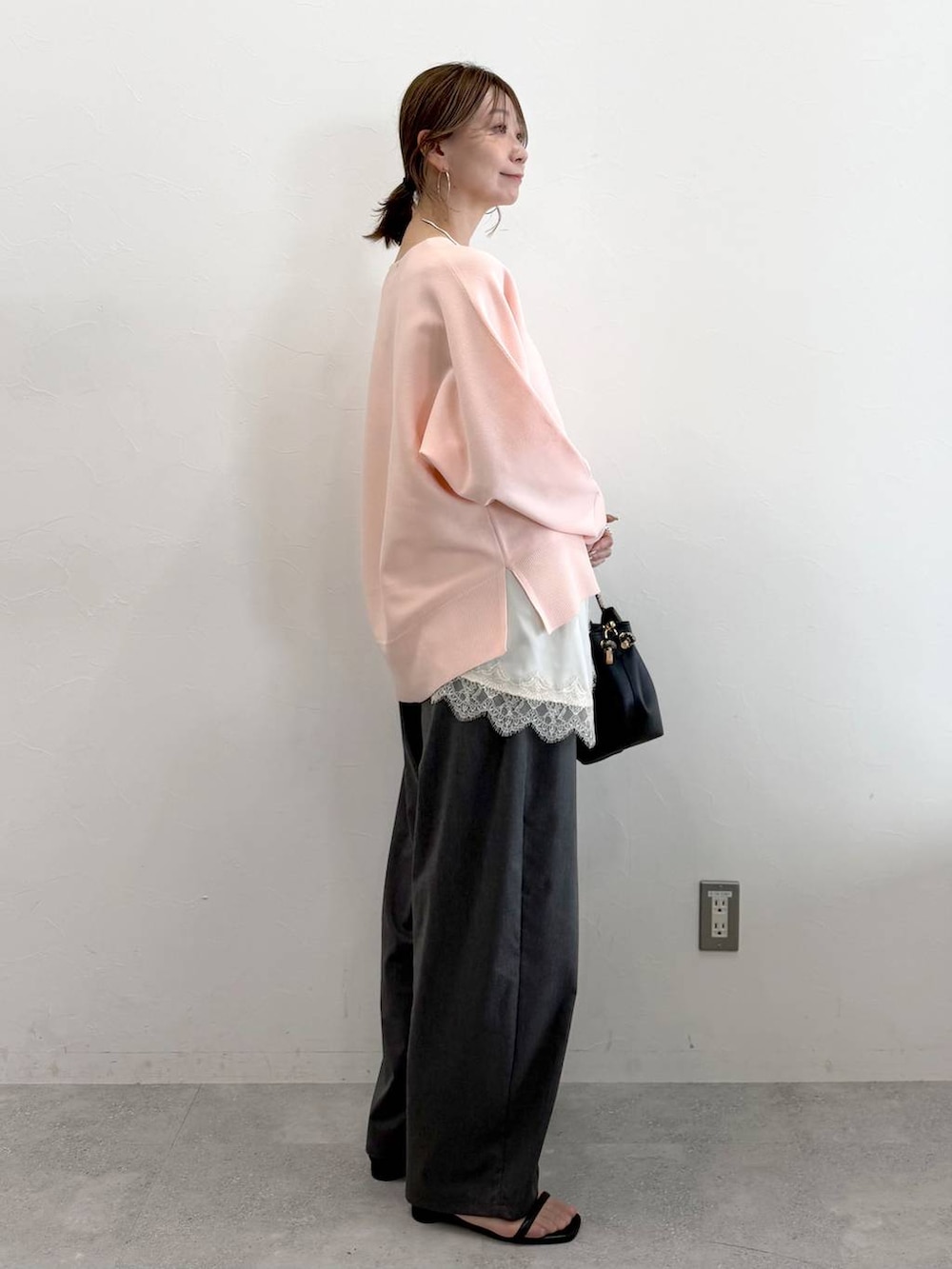 ホワイト系のキャミソール、グレー系のその他パンツ、ブラック系のハンドバッグを着用したレディースの春コーディネートの3枚目の写真