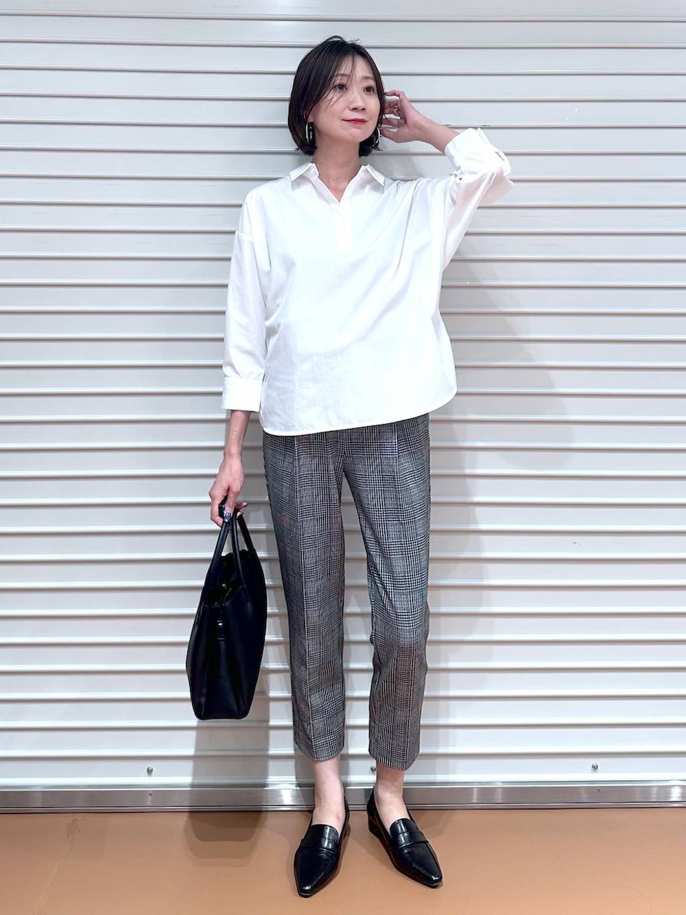 グレー系のニット/セーター、ブラック系のその他パンツ、ブラック系のハンドバッグを着用したレディースの秋コーディネートの2枚目の写真