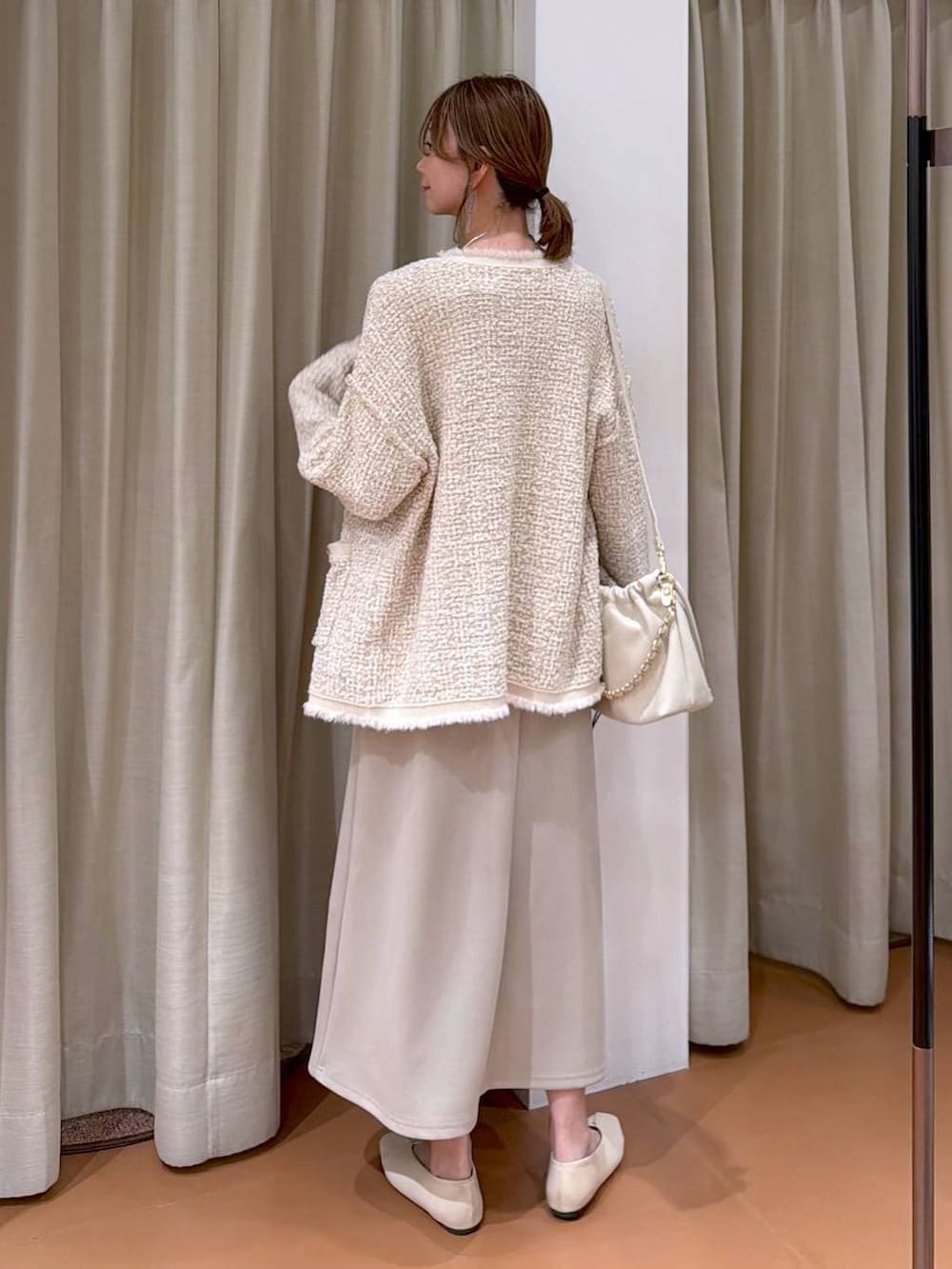 グレー系のTシャツ/カットソー、ホワイト系のハンドバッグ、ホワイト系のパンプスを着用したレディースの春コーディネートの4枚目の写真