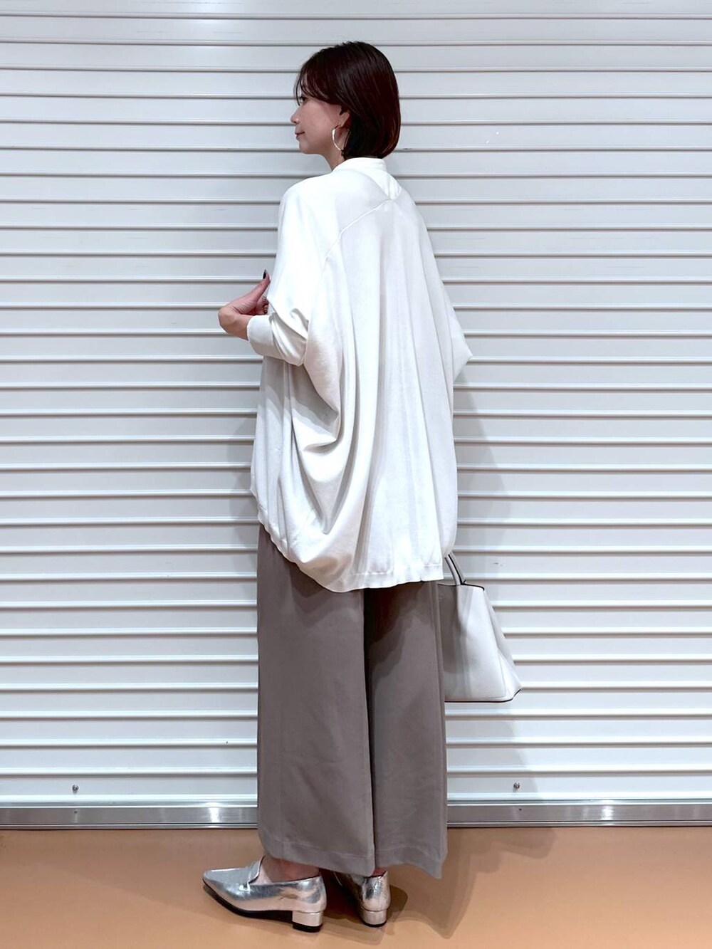 ブラウン系のその他パンツ、グレー系のカーディガン/ボレロ、グレー系のハンドバッグを着用したレディースの秋コーディネートの4枚目の写真