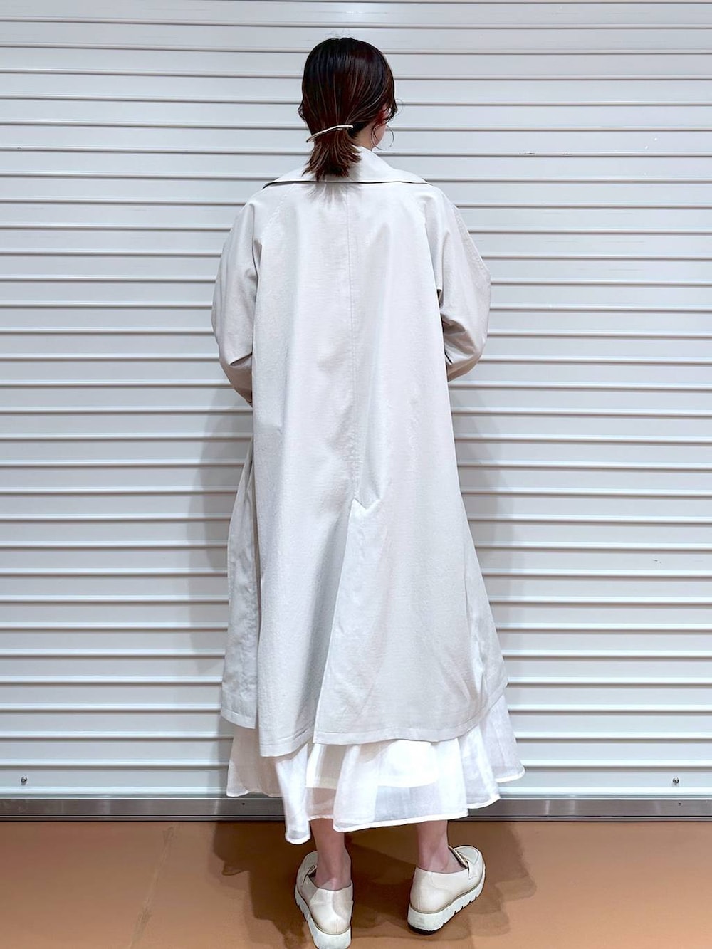 ホワイト系のスカート、ホワイト系のローファー、ホワイト系のハンドバッグを着用したレディースの冬コーディネートの3枚目の写真