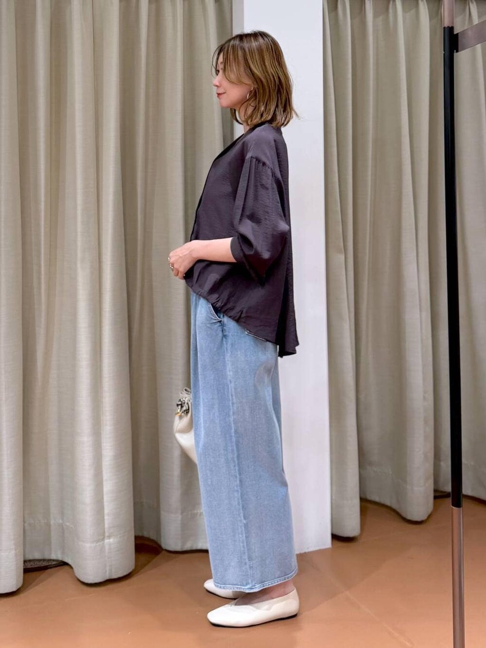 ホワイト系のパンプス、ブルー系のデニムパンツ、ホワイト系のハンドバッグを着用したレディースの春コーディネートの5枚目の写真