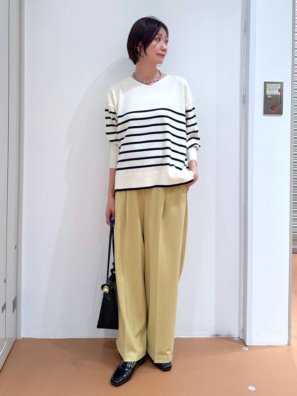 イエロー系のその他パンツ、ブルー系のニット/セーター、ブラック系のパンプスを着用したレディースの冬コーディネートの2枚目の写真