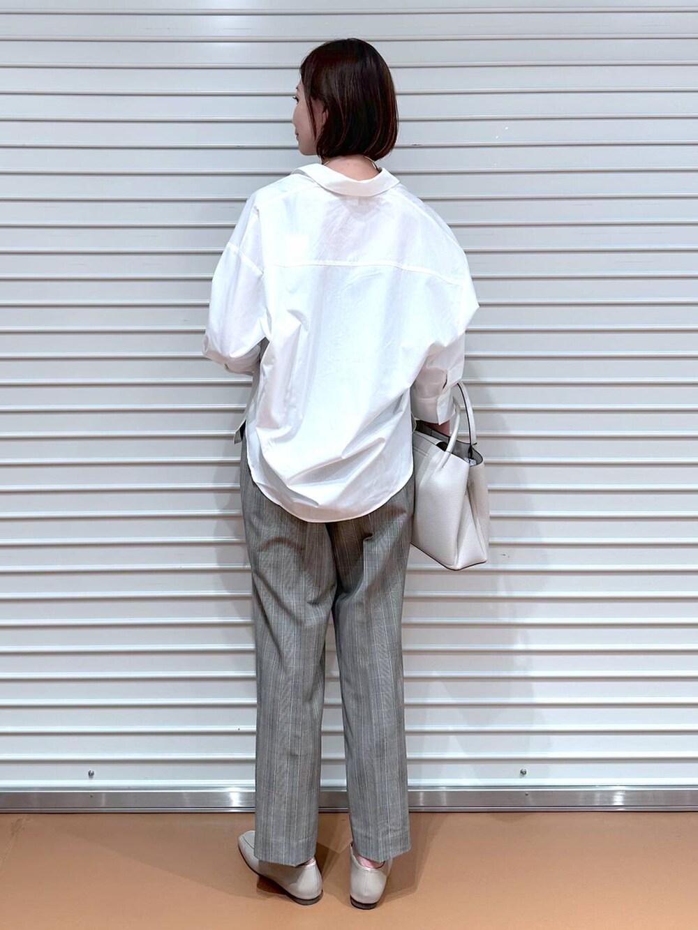 ブラウン系のその他パンツ、グレー系のハンドバッグ、ホワイト系のシャツ/ブラウスを着用したレディースの秋コーディネートの4枚目の写真