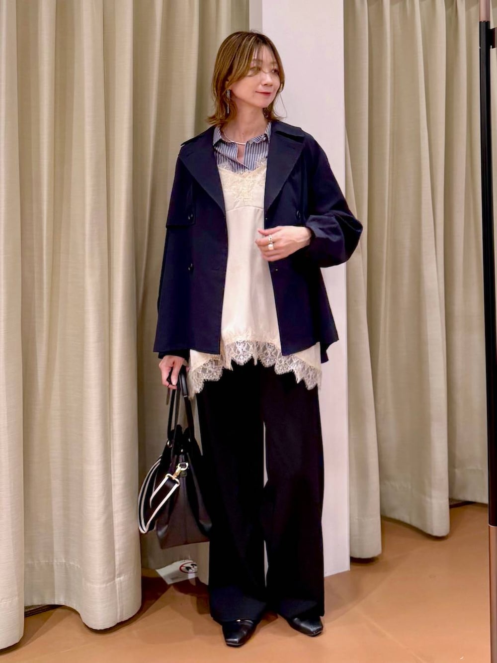 ブラック系のその他パンツ、ブラック系のパンプス、ホワイト系のキャミソールを着用したレディースの春コーディネートの2枚目の写真