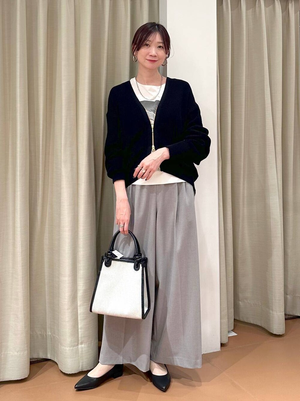 ホワイト系のTシャツ/カットソー、グレー系のその他パンツ、ブラック系のカーディガン/ボレロを着用したレディースの春コーディネートの2枚目の写真