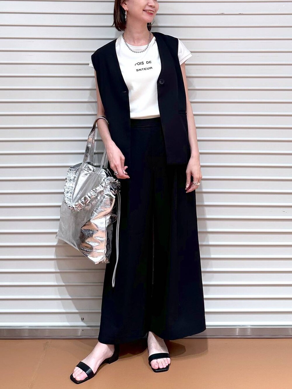 ブラック系のベスト、ホワイト系のTシャツ/カットソー、ブラック系のその他パンツを着用したレディースの夏コーディネートの5枚目の写真