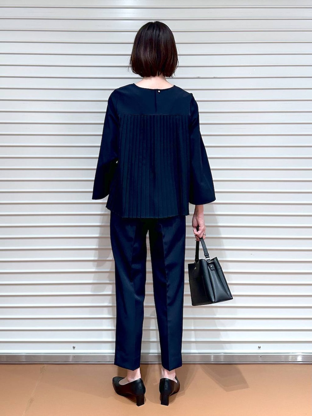 ブルー系のシャツ/ブラウス、ブルー系のその他パンツ、ブラック系のハンドバッグを着用したレディースの冬コーディネートの3枚目の写真