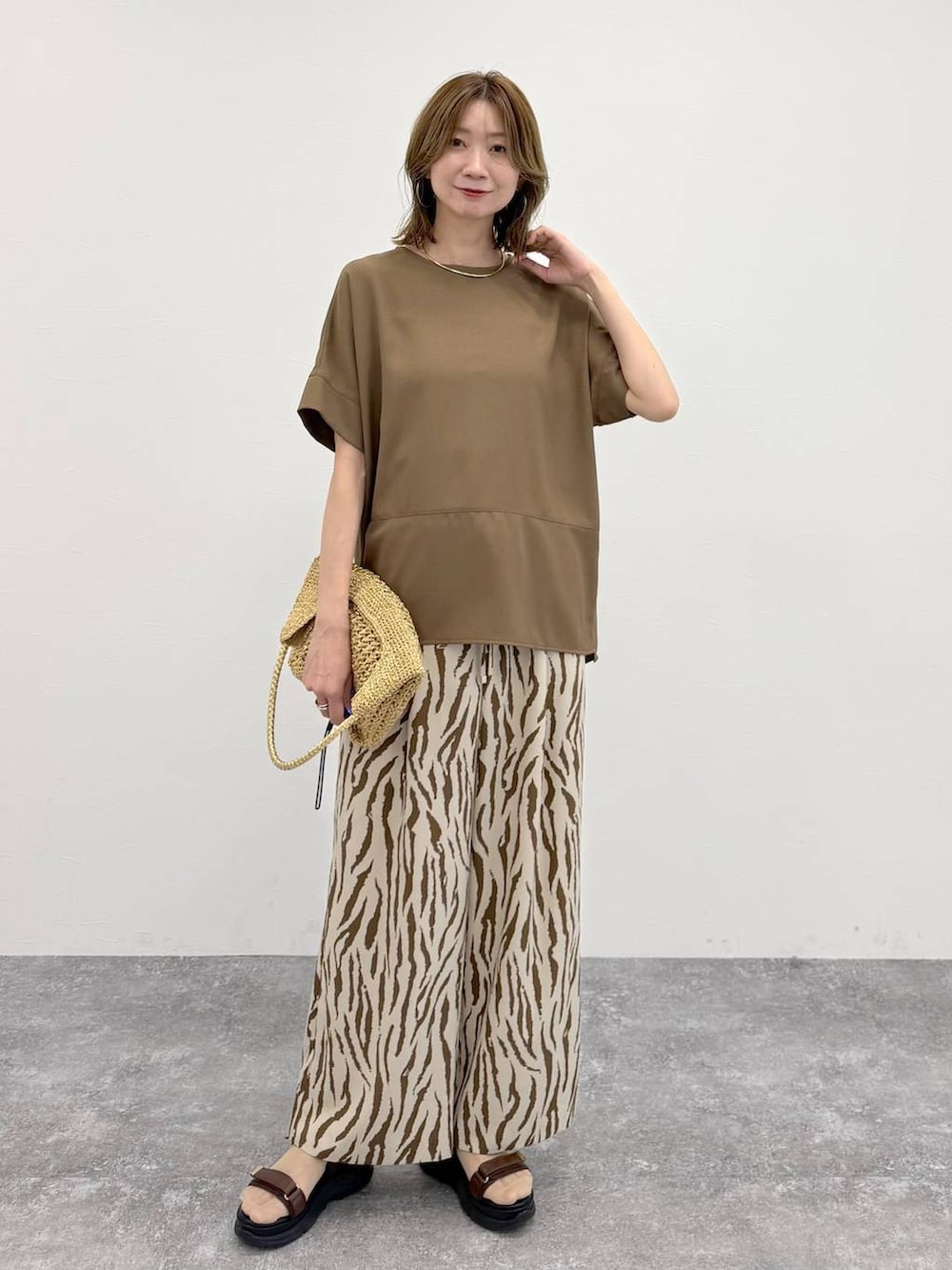 ゴールド系のトートバッグ、その他のその他パンツ、ブラウン系のTシャツ/カットソーを着用したレディースの春コーディネートの2枚目の写真