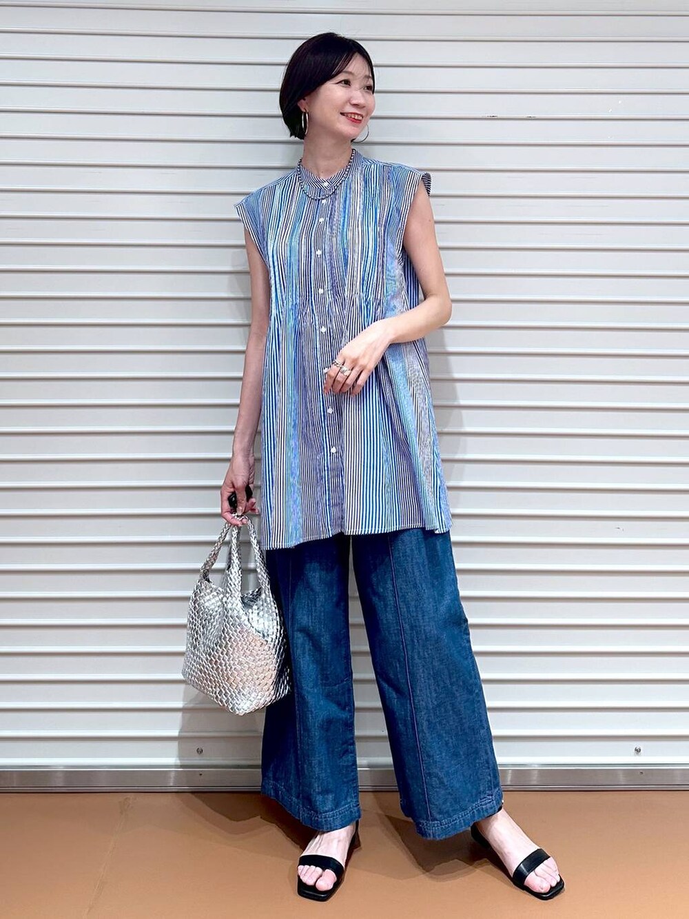 ブルー系のデニムパンツ、ブルー系のデニムパンツ、シルバー系のトートバッグを着用したレディースの夏コーディネートの2枚目の写真