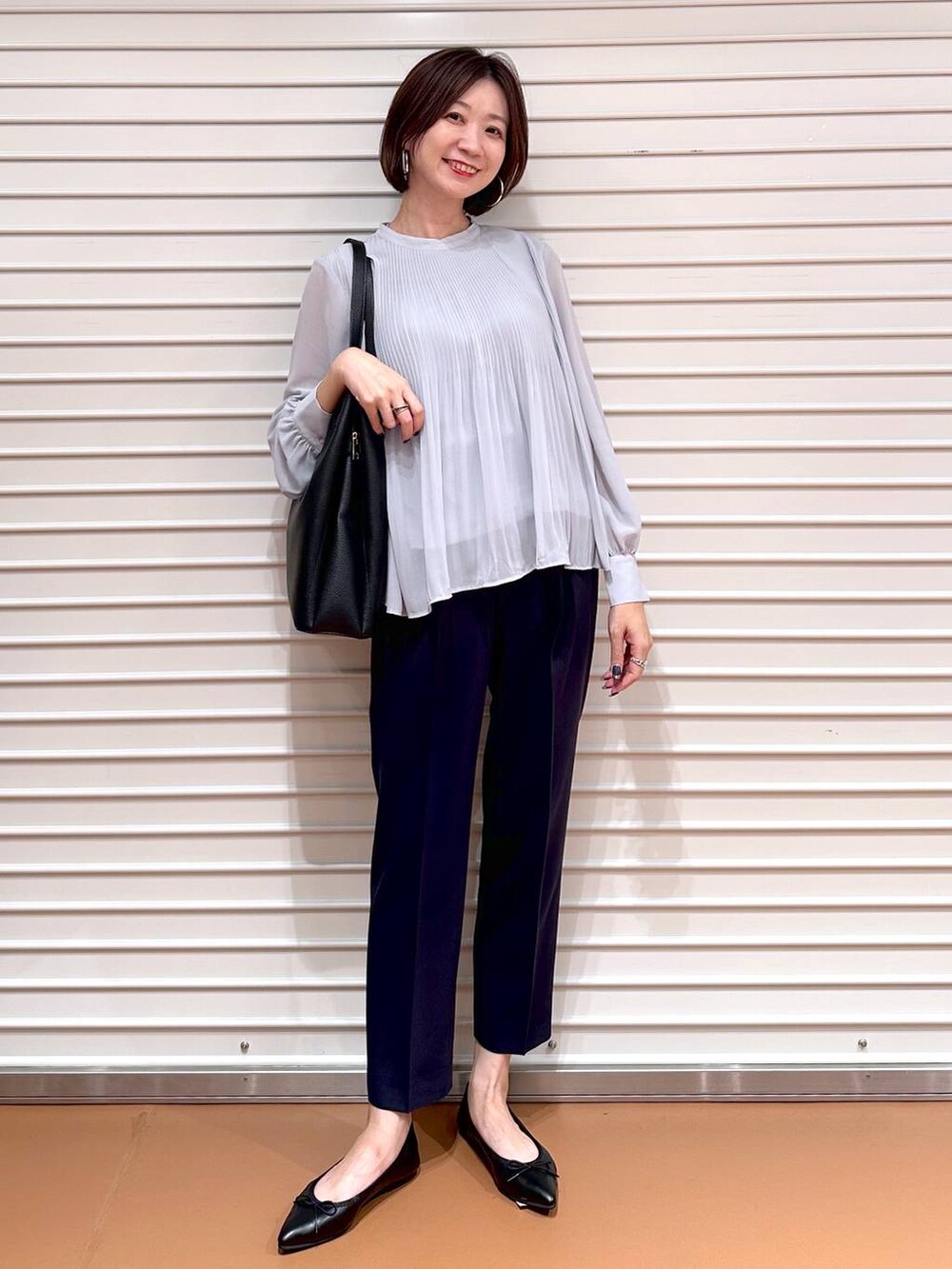 ブルー系のその他パンツ、ブラック系のトートバッグ、ブラック系のパンプスを着用したレディースの秋コーディネートの2枚目の写真