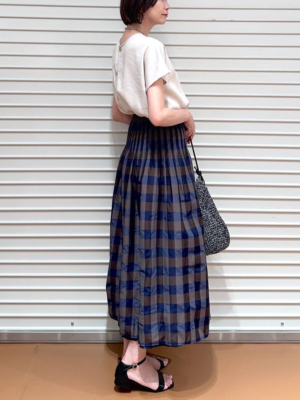 ベージュ系のシャツ/ブラウス、ブラウン系のスカート、ブラック系のサンダルを着用したレディースの夏コーディネートの6枚目の写真