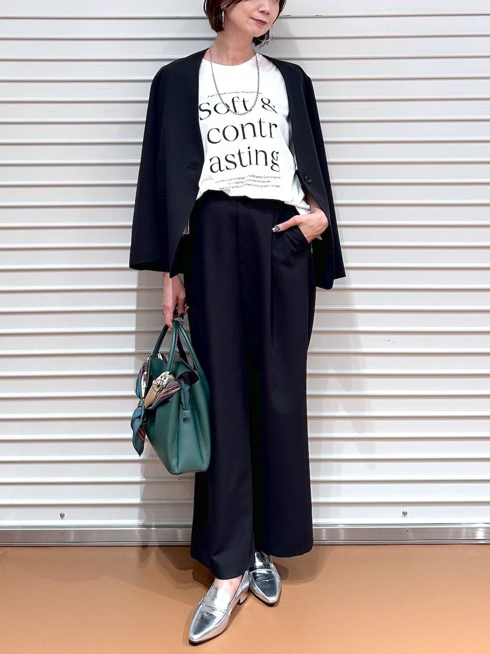 ブラック系のその他アウター、ブラック系のその他パンツ、ホワイト系のTシャツ/カットソーを着用したレディースの秋コーディネートの5枚目の写真