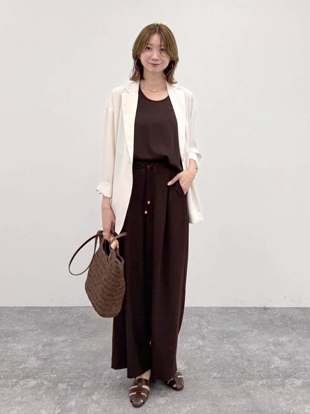 ブラウン系のパンプス、ブラウン系のその他パンツ、ホワイト系のテーラードジャケットを着用したレディースの春コーディネートの6枚目の写真