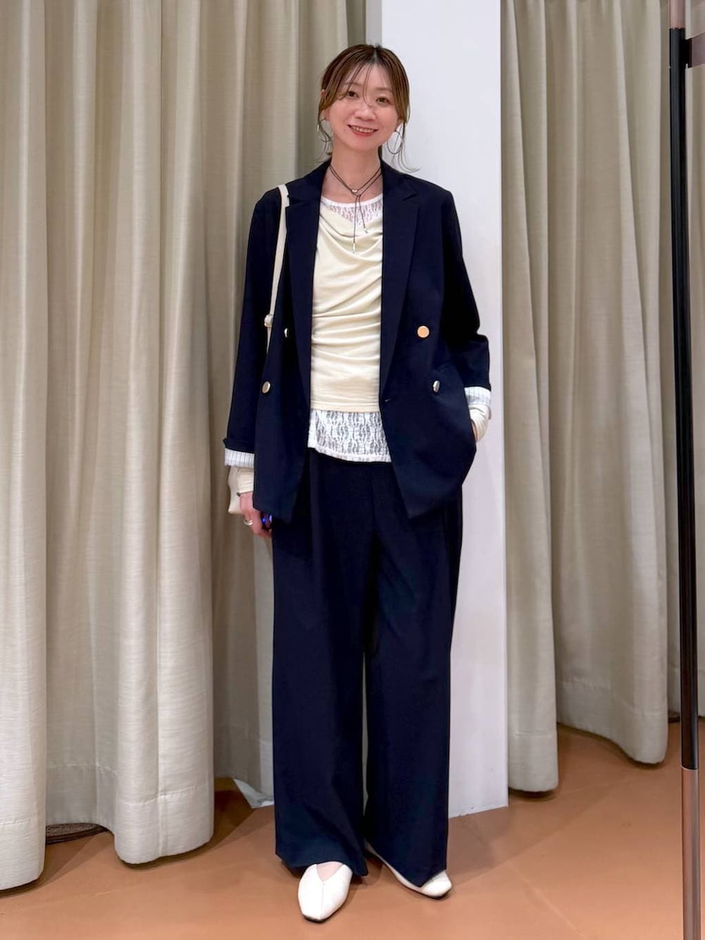 ホワイト系のハンドバッグ、ホワイト系のパンプス、ブルー系のその他パンツを着用したレディースの春コーディネートの2枚目の写真