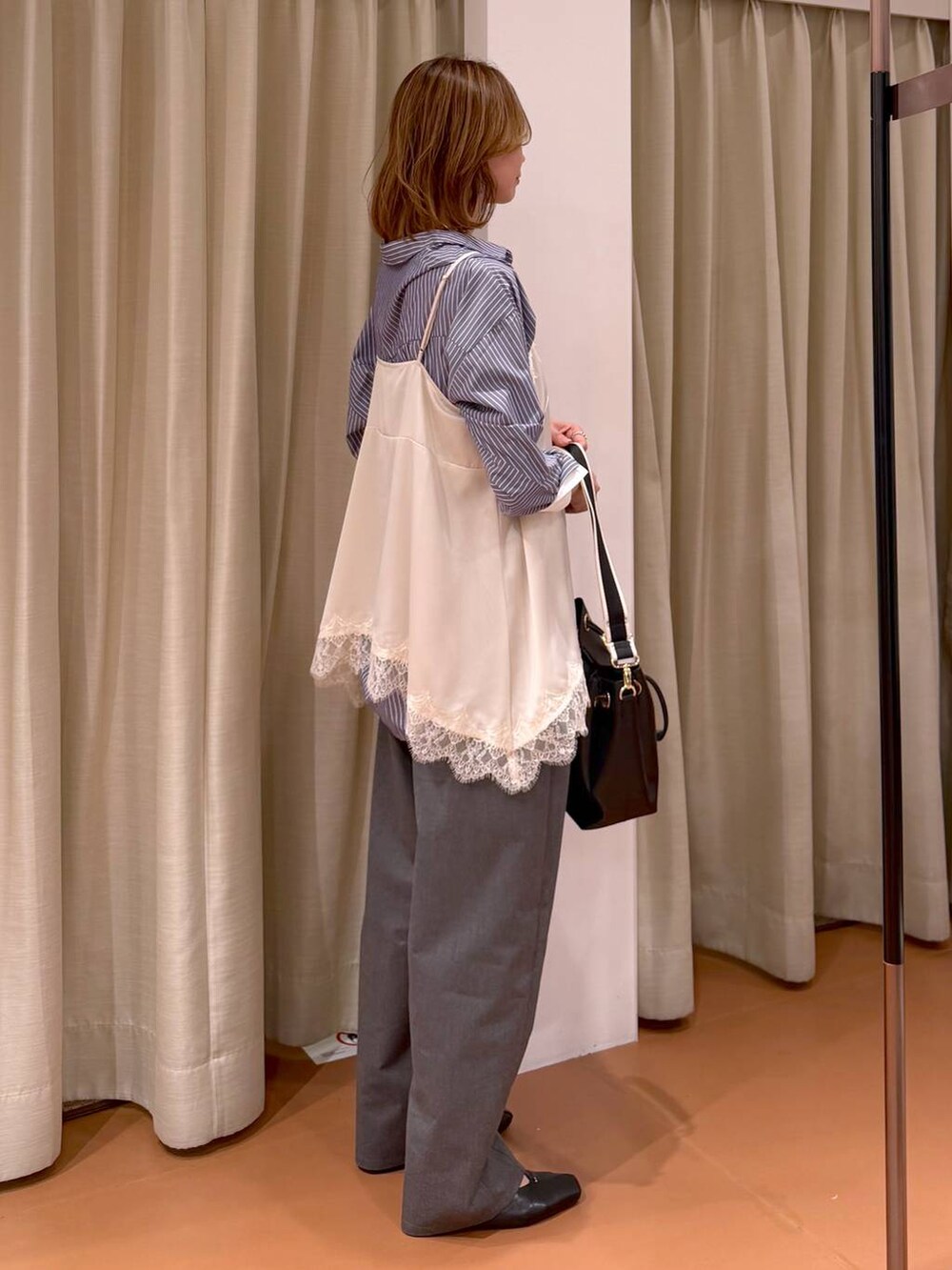 ブラック系のパンプス、ホワイト系のキャミソール、ブラック系のトートバッグを着用したレディースの春コーディネートの5枚目の写真