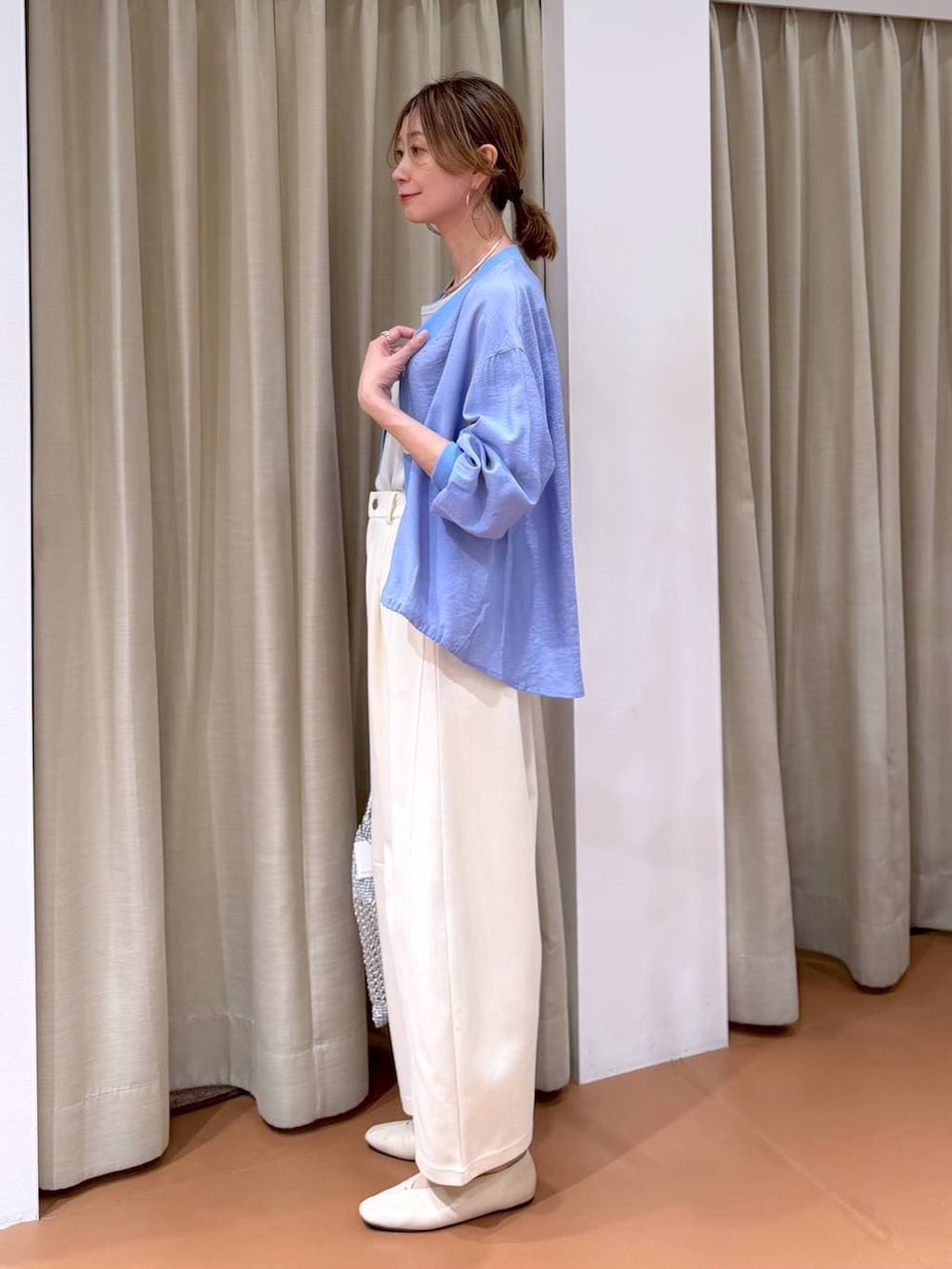 ホワイト系のTシャツ/カットソー、ホワイト系のパンプス、ブルー系のカーディガン/ボレロを着用したレディースの春コーディネートの3枚目の写真