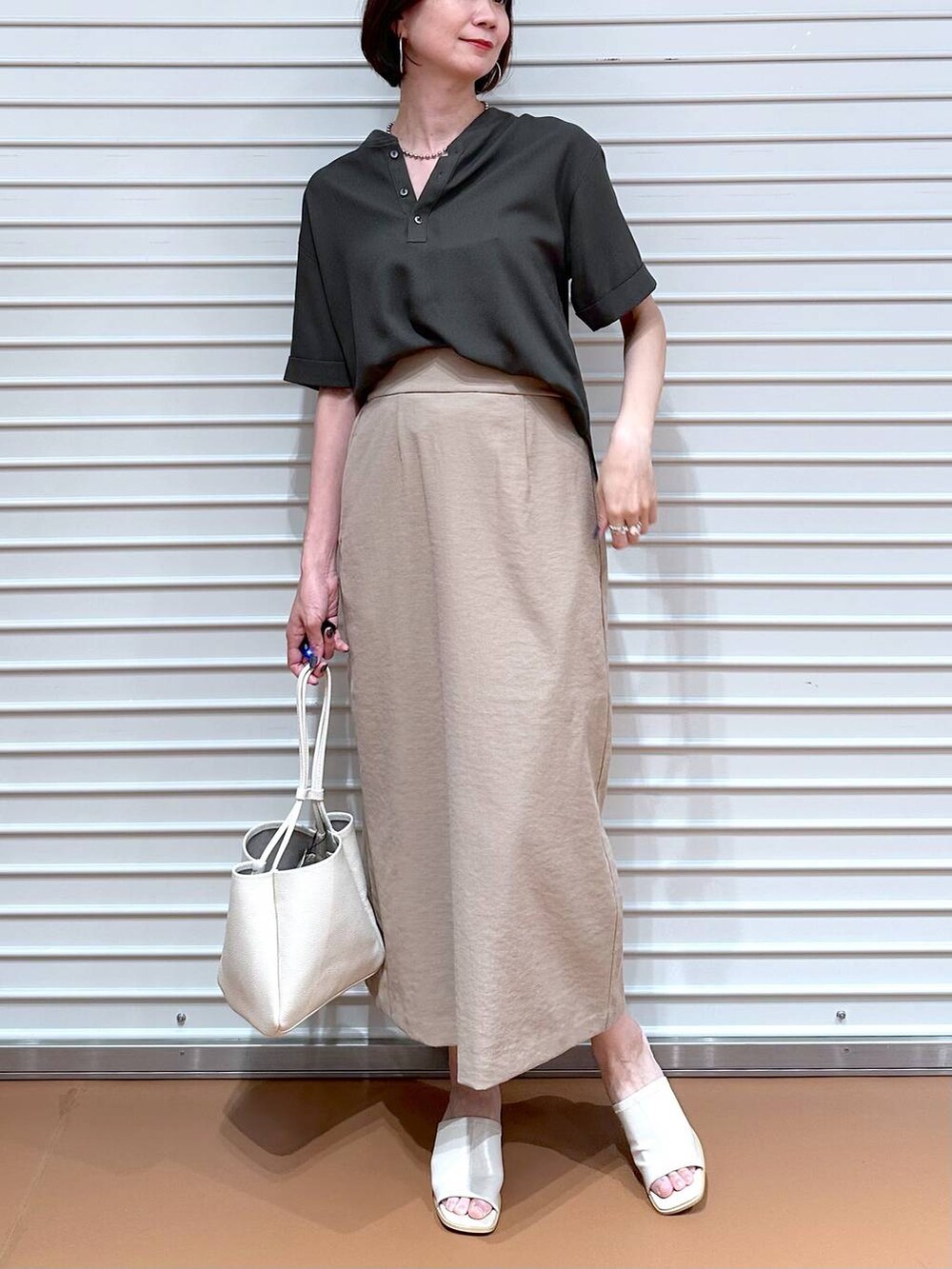 ベージュ系のスカート、グリーン系のシャツ/ブラウスを着用したレディースの夏コーディネートの4枚目の写真