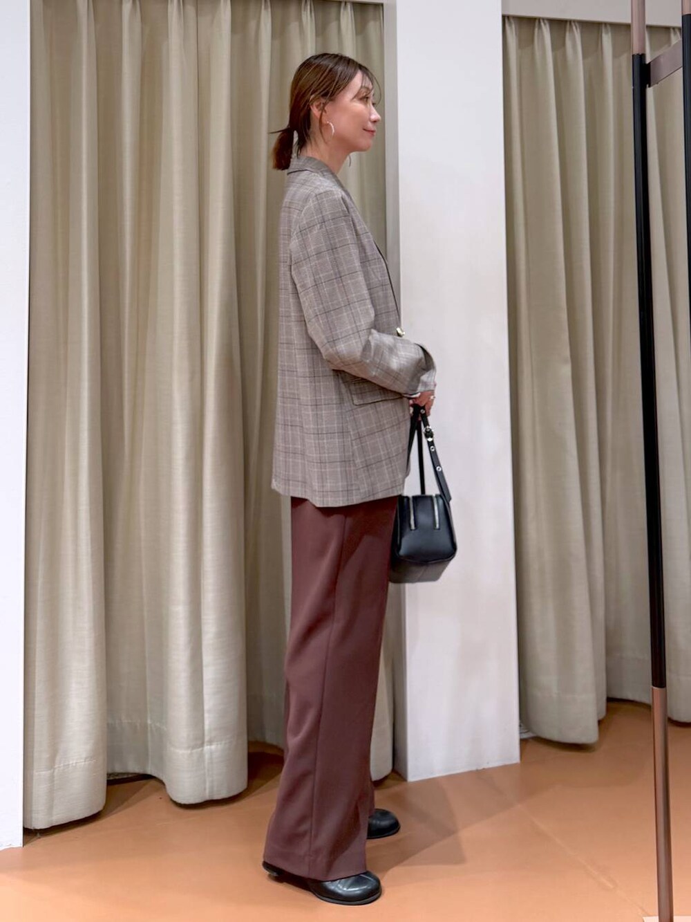 ブラック系のブーツ、ブラック系のテーラードジャケット、ブラック系のショルダーバッグを着用したレディースの冬コーディネートの5枚目の写真