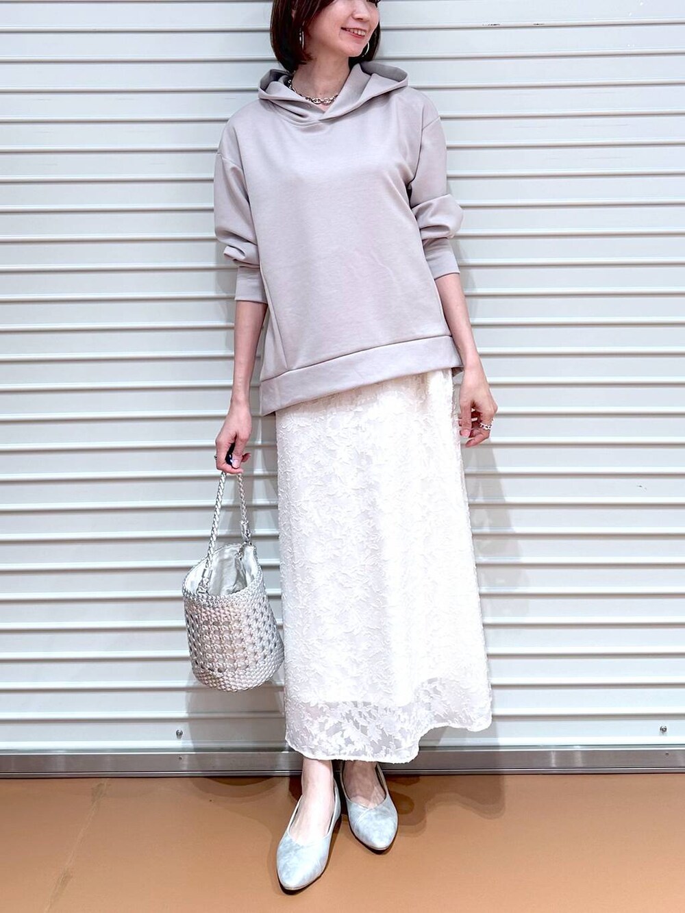 ベージュ系のパーカー、シルバー系のパンプス、ホワイト系のスカートを着用したレディースの春コーディネートの6枚目の写真