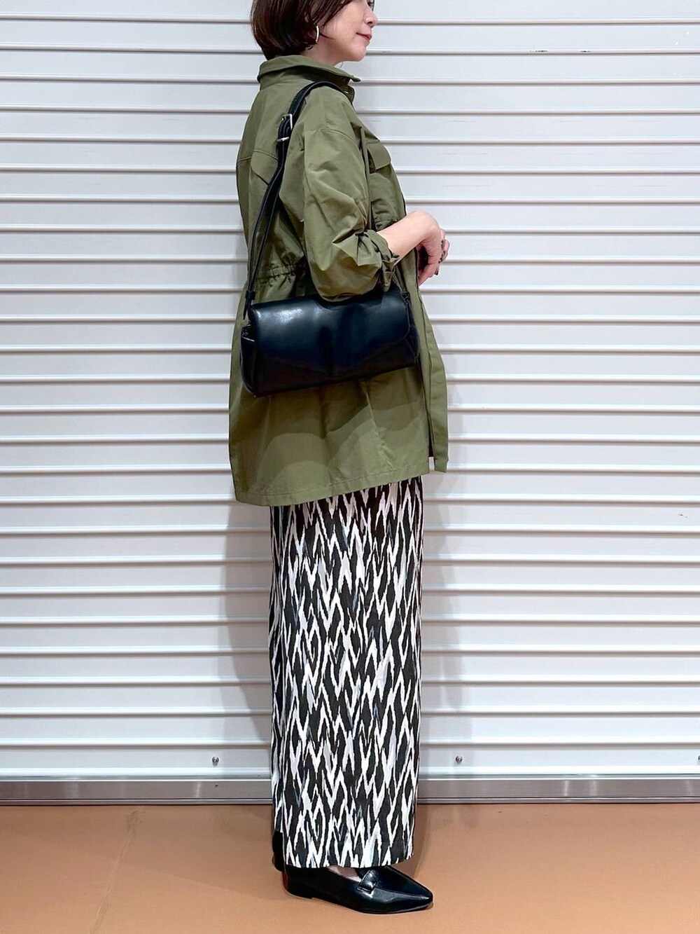 ブラック系のローファー、ホワイト系のTシャツ/カットソー、グリーン系のその他アウターを着用したレディースの秋コーディネートの6枚目の写真