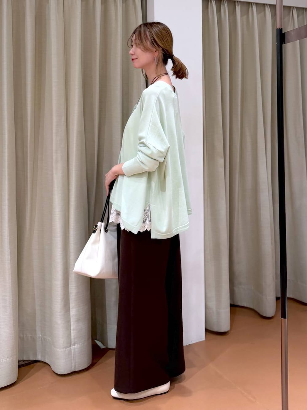 ホワイト系のパンプス、ホワイト系のタンクトップ、ホワイト系のトートバッグを着用したレディースの春コーディネートの7枚目の写真