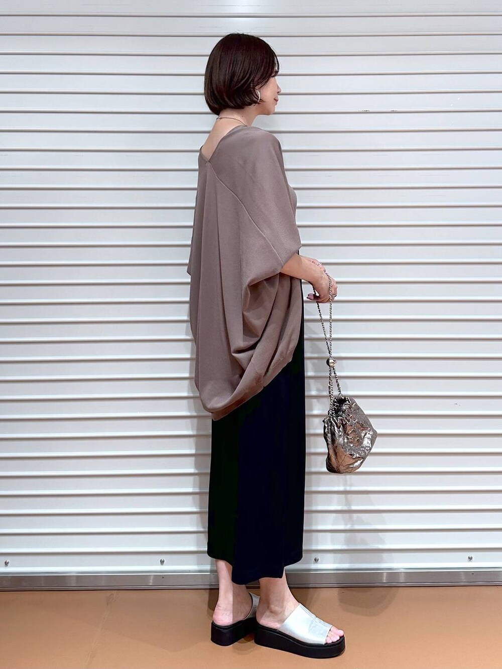 ブラック系のスカート、ブラウン系のカーディガン/ボレロ、シルバー系のサンダルを着用したレディースの夏コーディネートの3枚目の写真