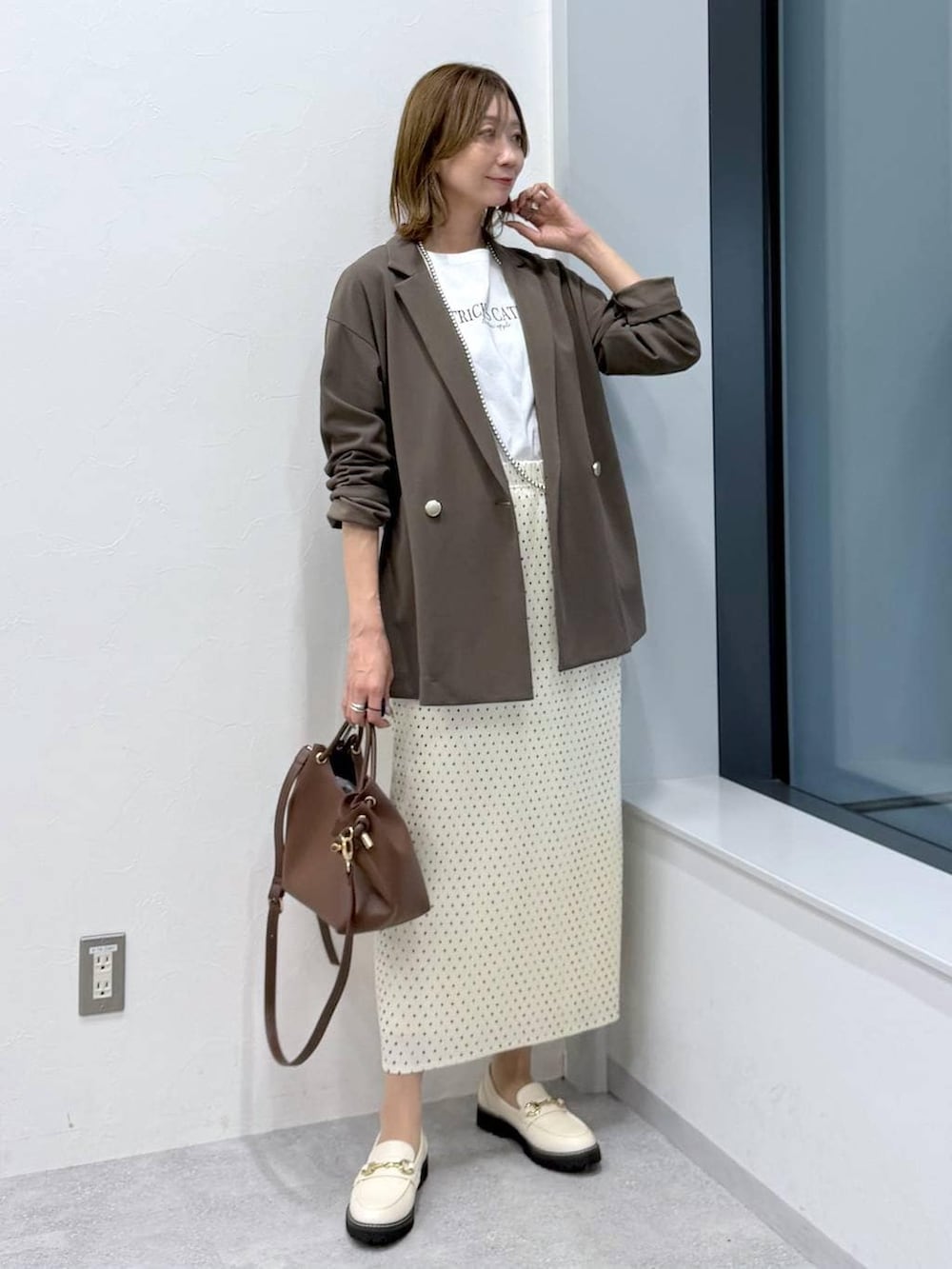 ホワイト系のスカート、ホワイト系のローファー、ホワイト系のTシャツ/カットソーを着用したレディースの冬コーディネートの2枚目の写真