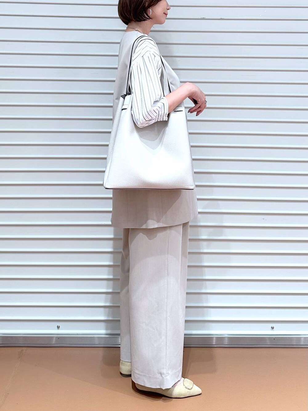 ブラック系のシャツ/ブラウス、ベージュ系のその他パンツ、ベージュ系のベストを着用したレディースの秋コーディネートの6枚目の写真