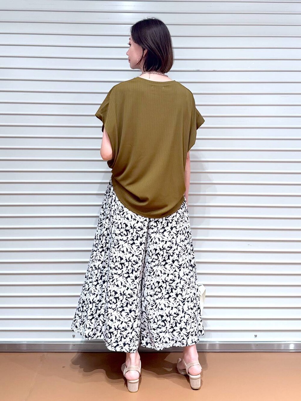 グリーン系のTシャツ/カットソー、ベージュ系のサンダル、ブラック系のその他パンツを着用したレディースの夏コーディネートの4枚目の写真