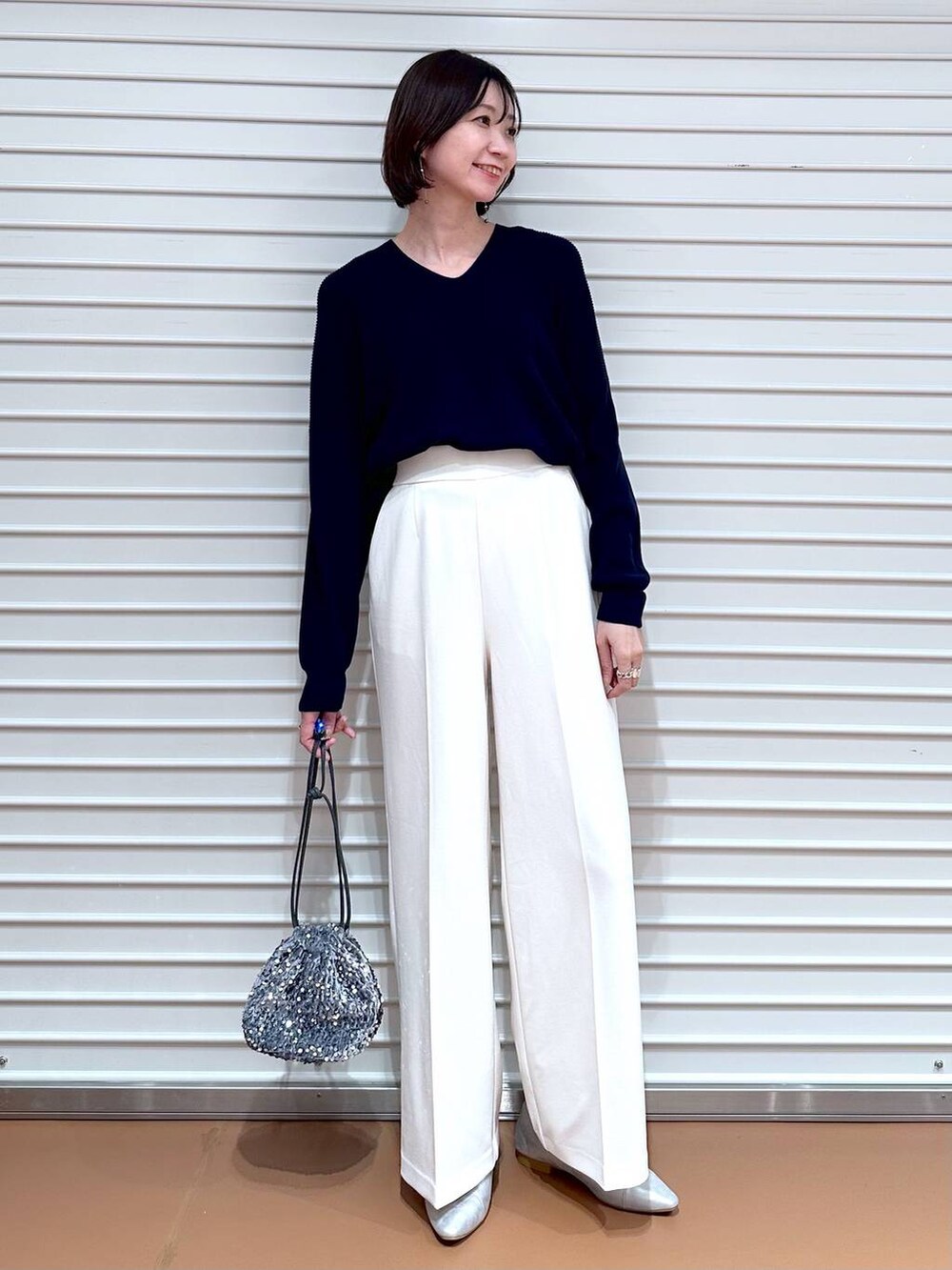 ブルー系のニット/セーター、シルバー系のパンプスを着用したレディースの春コーディネートの2枚目の写真