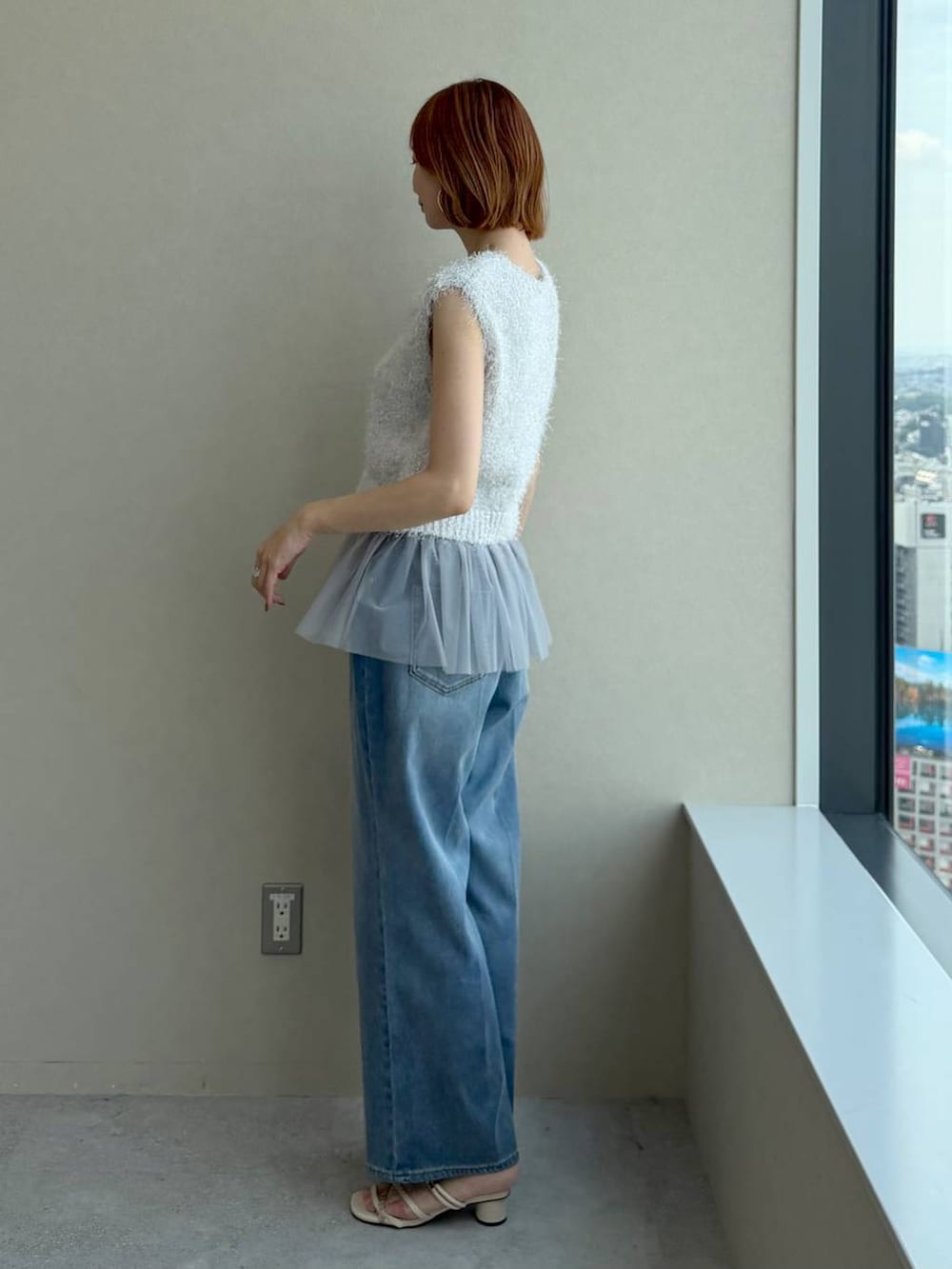グレー系のニット/セーター、ホワイト系のサンダル、ブラウン系のかごバッグを着用したレディースの夏コーディネートの5枚目の写真