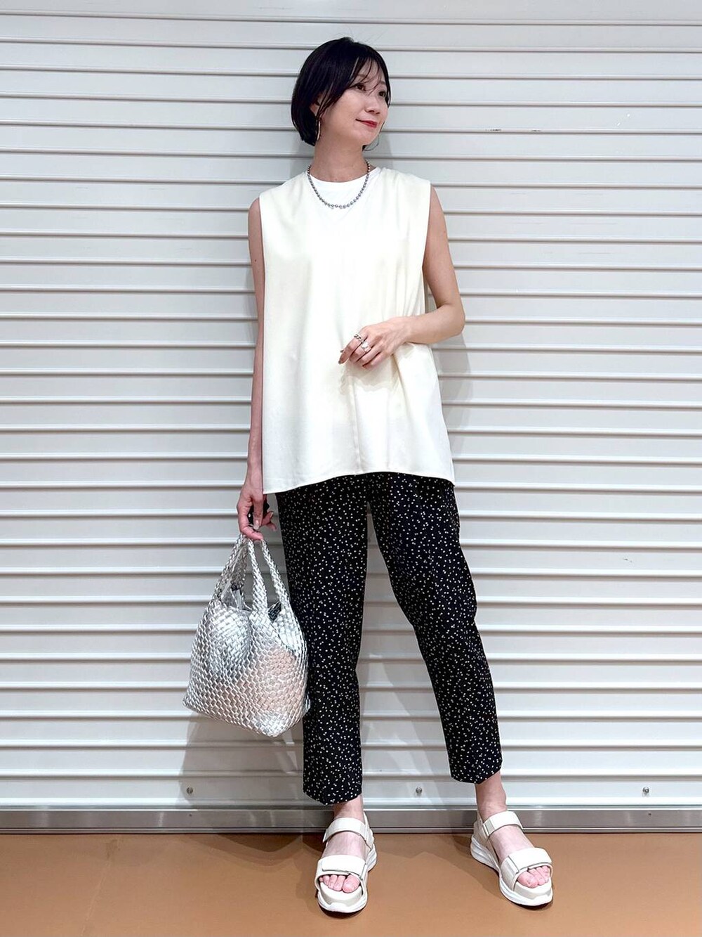 ホワイト系のシャツ/ブラウス、シルバー系のトートバッグ、ホワイト系のサンダルを着用したレディースの夏コーディネートの2枚目の写真