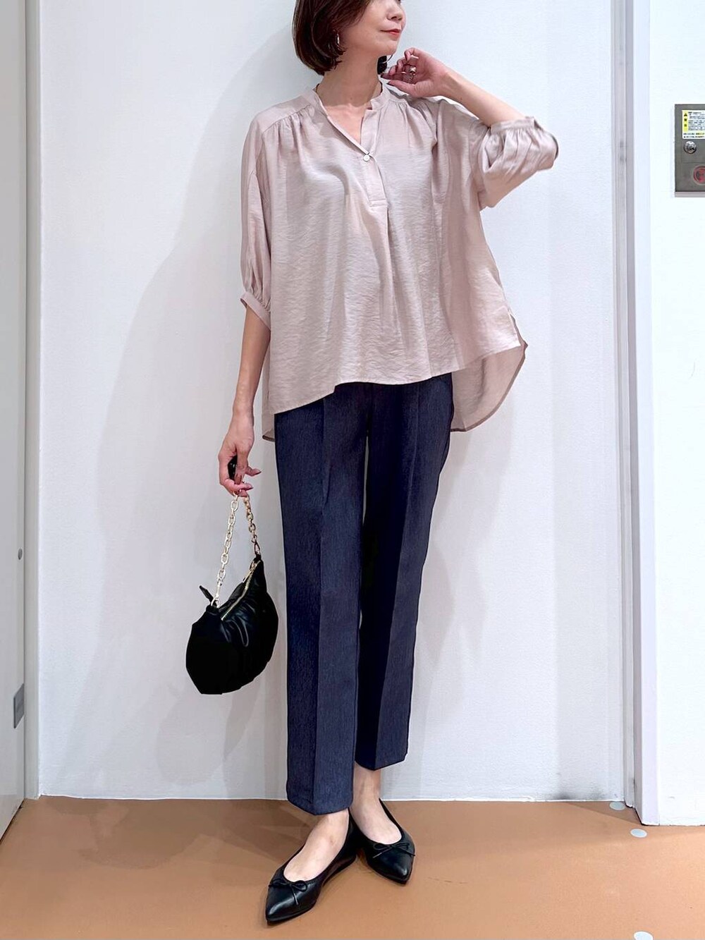 ベージュ系のシャツ/ブラウス、ブラック系のパンプス、ブルー系のデニムパンツを着用したレディースの秋コーディネートの5枚目の写真